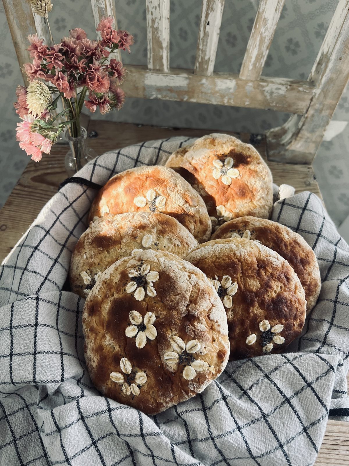 Nybakade glutenfria frallor i en korg med rutig duk